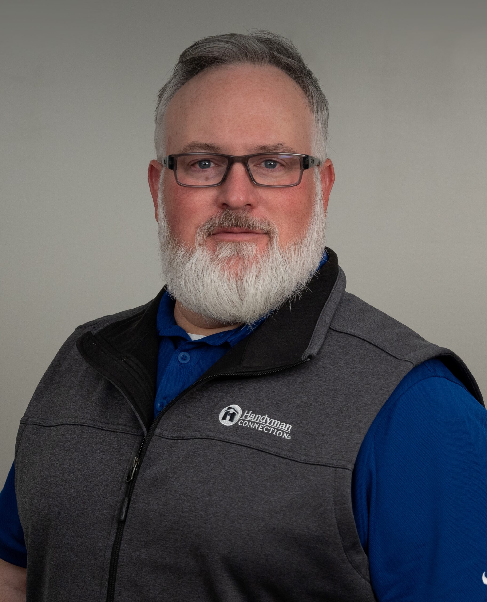 man wearing a blue shirt and gray vest